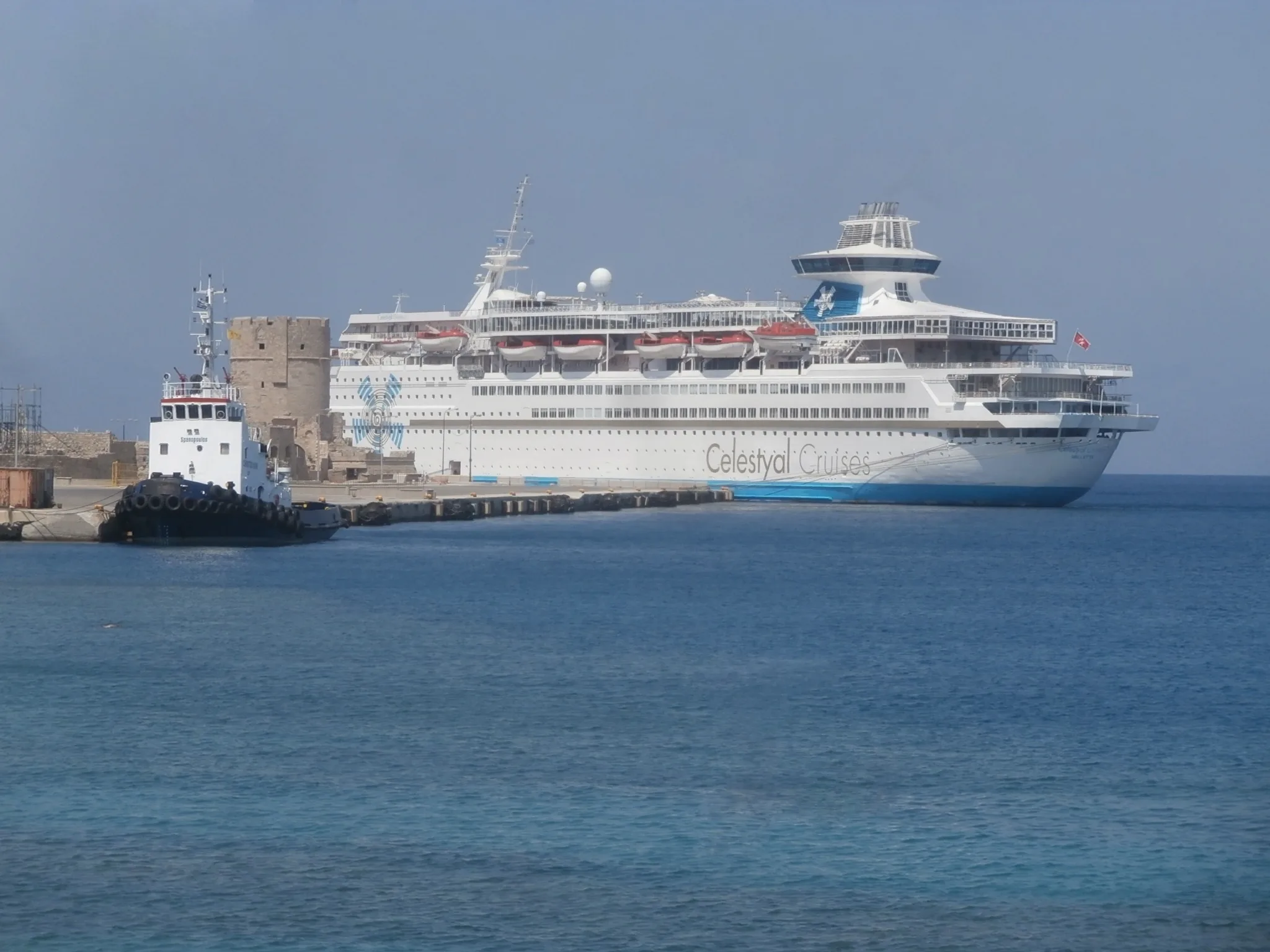Wikimedia Commons (https://touristwire.com/wp-content/uploads/2023/05/Christos_XXVII_and_Celestyal_Olympia_moored_at_Quay_in_Port_of_Rhodes_4_September_2019.jpg)