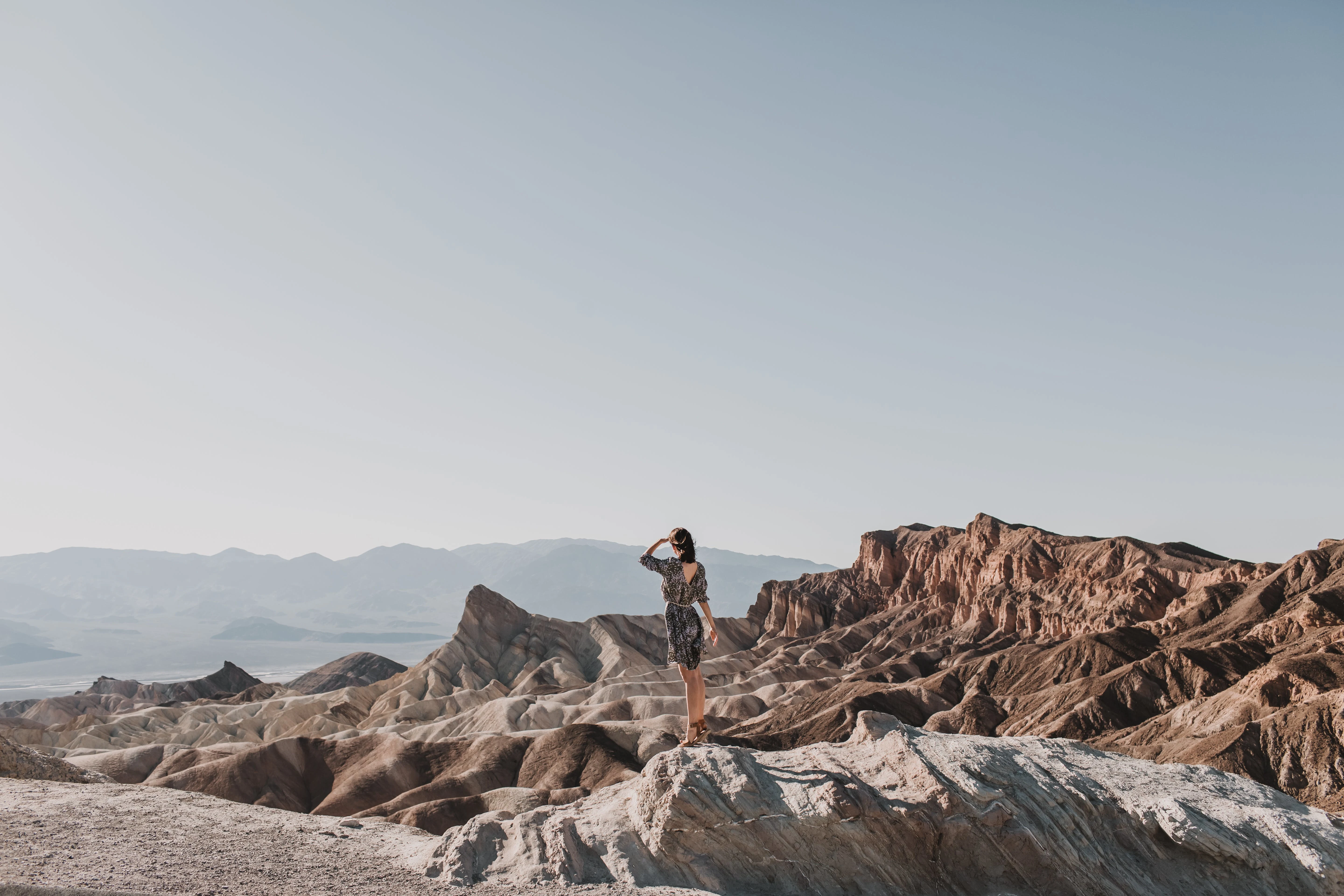 Free Back View Shot of a Woman Standing on a Rocky Mountain Stock Photo