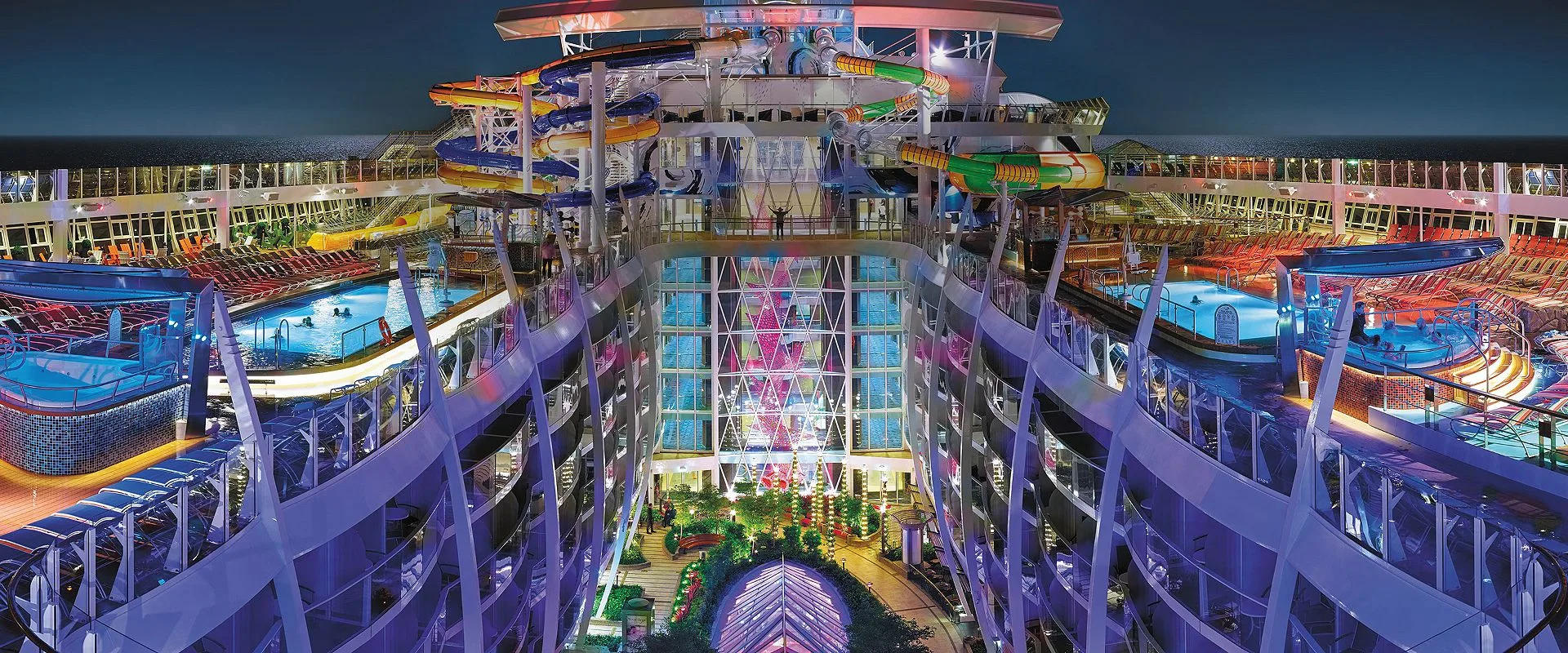 Image of Harmony of the Seas Central Park, sourced from: Royal Caribbean International https://touristwire.com/wp-content/uploads/2023/06/harmony-perfect-storm-central-park-pool-deck-nightime-overview-hero-asset.jpg