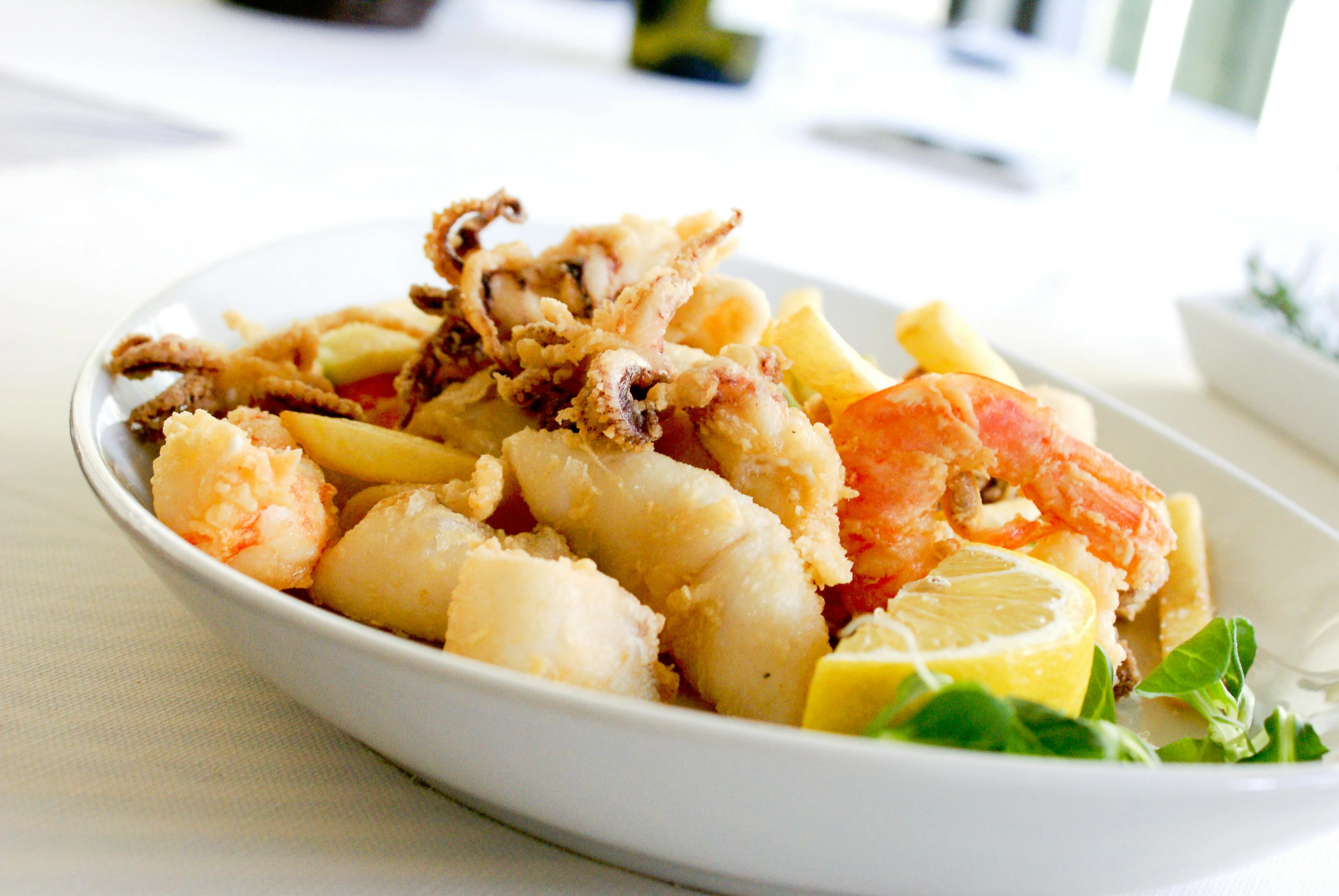 Free Deep Fried Shrimp and Squid With Slice of Lemon on Ceramic Plate Stock Photo